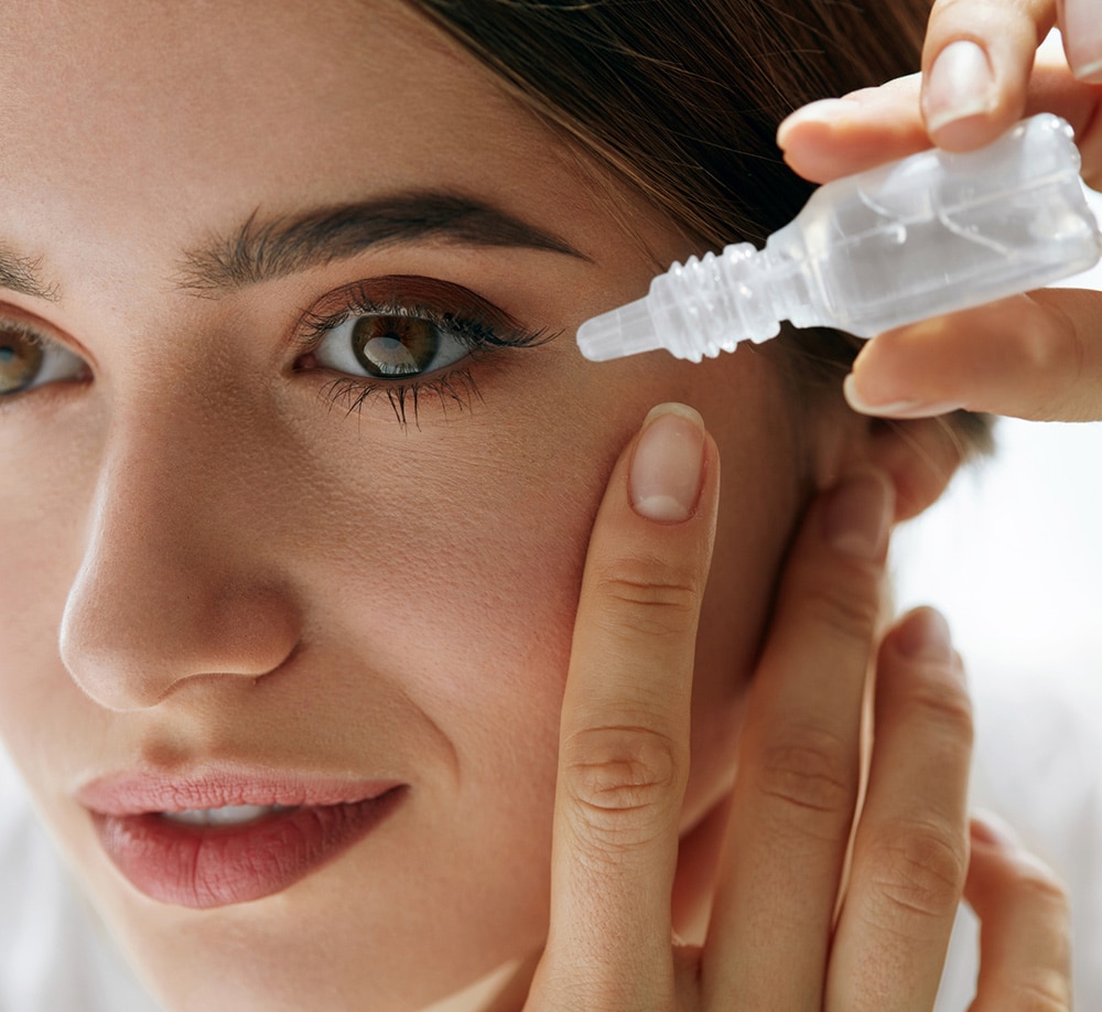 female patient putting eyedrops in for dry eye treatment