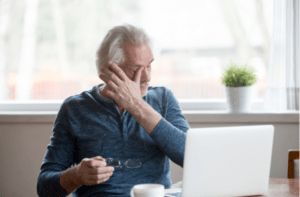 Fatigued mature old man taking off glasses