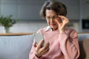 Older woman with glasses struggling to see because of cataracts in Loveland, CO