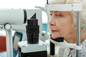 Older woman having her eyes checked for glaucoma at the eye doctor in Loveland, CO