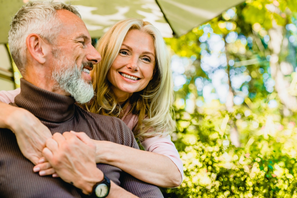 Older woman and man smiling happily together after retina damage care in Loveland, CO