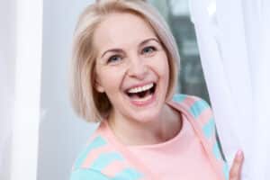 Woman smiling after cataract surgery seeing clearly in Loveland, CO