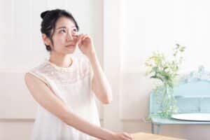 Woman touching her eye due to dry eye symptoms in Loveland, CO